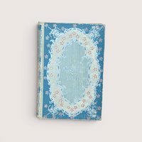 An antique blue and cream hardcover book featuring an ornate floral filigree border on the front cover