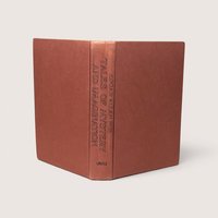 A vintage terracotta orange cloth hardcover book spine standing upright against a neutral backdrop