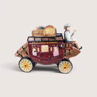 Ceramic Wells Fargo and Company stagecoach figurine with a driver and passengers, centered on a plain linen background.