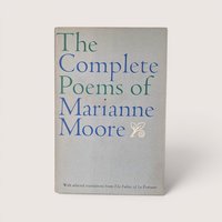 A vintage 1967 hardcover edition of The Complete Poems of Marianne Moore with blue and green typography on a gray dust jacket.