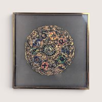 A framed 1997 mixed media painting by Barbara DeVault titled Decadisk featuring a textured circular paper medallion.