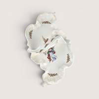 White ceramic divided serving dish with an integrated center handle, featuring an illustration of an angel holding a book surrounded by holly leaf accents, centered on a plain linen background.