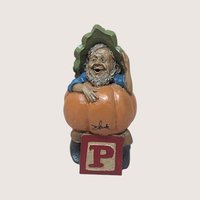 1991 Tom Clark signed Peter pumpkin gnome figurine sitting on a red alphabet letter P block on a linen background