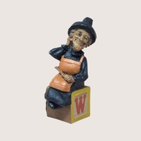 1994 Tom Clark signed Wanda witch figurine sitting on a yellow alphabet letter W toy block on a linen background
