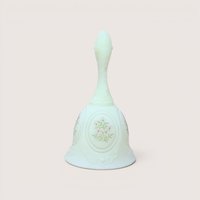 Light green custard glass dinner bell featuring a hand-painted bunch of small white and pink flowers within an oval medallion, centered on a plain linen background.