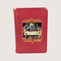 A vintage red textured leatherette catholic missal book featuring a central full color inlay illustration of the last supper.
