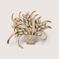 A vintage mid-century gold tone flower basket brooch filled with smooth white marquise milk glass cabochons