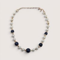 Vintage George statement necklace with dark blue glass beads, white pearls, and gold accents on a linen background