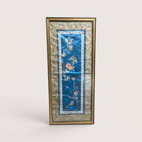 Vintage framed Chinese silk embroidery panel with a bird and chrysanthemums on a blue background and a linen backdrop