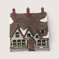 A handpainted porcelain Dept 56 Wackford Squeers Boarding School building on a linen background
