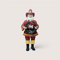 Vintage Fabriche Kurt Adler Santa Claus dressed in a red fireman uniform holding a green wreath with a dog bone.