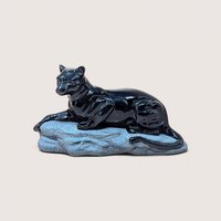 Vintage 1994 hand-painted high-gloss black panther ceramic figurine reclining on a textured grey rock base.