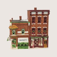 A handpainted porcelain Dept 56 Variety Store and Barber Shop building on a linen background