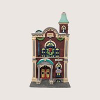 A handpainted porcelain Dept 56 Arts Academy building on a linen background