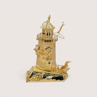 Intricate 1998 Danbury Mint gold plated Christmas ornament shaped like a lighthouse with Santa flying past.