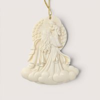 Cream colored relief style Christmas ornament depicting the Madonna holding up baby Jesus among stars and clouds.