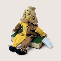 Vintage Judy Hunter handcrafted scarecrow musical shelf sitter perched on a book, playing "If I Only Had a Brain."