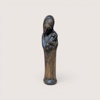 A slender hand carved wooden statue of Mary holding the infant Jesus on a plain background