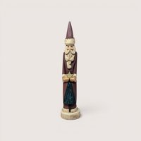 A tall, slender vintage hand-carved wooden Santa Claus figurine holding a gold star above a small green tree.