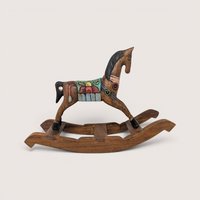 A vintage hand-carved wooden rocking horse figurine with a painted colorful saddle, black mane, and black hooves.