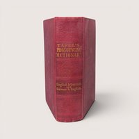An antique 1870 hardcover pocket dictionary with a worn red cloth spine and gold gilt lettering.