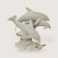Vintage Lenox ivory cream porcelain sculpture of three dolphins leaping over gold gilded ocean waves.