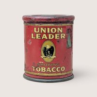A vintage red Union Leader Smoking Tobacco cylindrical tin with an eagle emblem on a plain background