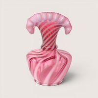 A pink and white spiral swirl opalescent glass fan top vase with a wide flattened ruffled rim on a beige backdropA pink and white spiral swirl opalescent glass jack in the pulpit vase on a light beige background