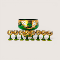 Emerald green bohemian glass punch bowl and eight matching cordial stem glasses with heavy gold gilt on a solid background.