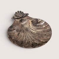 A vintage silver plated scallop shell shaped trinket dish with dark age tarnish on a plain white background