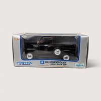 A black 1953 Chevrolet 3100 toy pickup truck sealed inside its original gray and blue Welly window display box