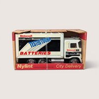 A vintage white Nylint Motorcraft Batteries toy delivery truck in its original red cardboard display box