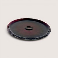 A round ruby red pressed glass cake server plate with a decorative scalloped edge on a plain background