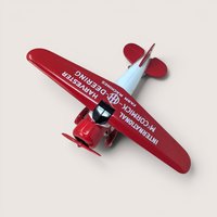 A burgundy and white International Harvester Lockheed Vega model airplane bank inside its original retail display packaging