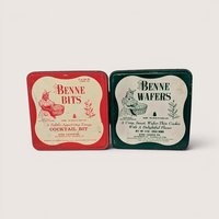 A pair of vintage square cookie tins from Byrd Cookie Co featuring red Benne Bits and green Benne Wafers on a light background