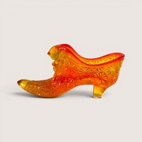 An amberina glass slipper figurine with a textured geometric pattern transitioning from yellow to red at the collar.