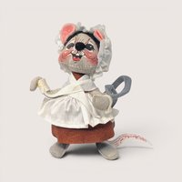 Annalee felt grey mouse doll wearing a white lace bonnet, white apron, and brown felt skirt.