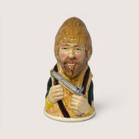 Vintage 1983 Royal Cornwall Robinson Crusoe ceramic character bell in brown and green glaze.