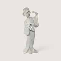 Vintage white porcelain Geisha figurine holding a fan in a traditional pose.
