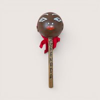Vintage handpainted wooden Grenada souvenir maraca with a red fabric head wrap.
