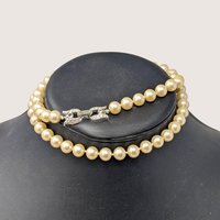Vintage faux pearl single-strand necklace featuring a decorative silver-tone rhinestone clasp.