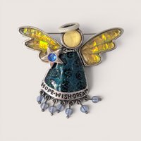 Vintage enamel and rhinestone angel brooch featuring iridescent wings, a glittery blue dress with "Hope Wish Dream" text, and dangling beads.