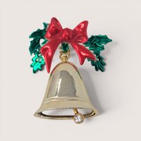 Vintage gold-tone Christmas bell brooch with red enamel bow, green holly leaves, and a rhinestone clapper.