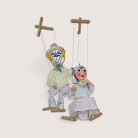 Pair of vintage string marionette puppets including a clown and companion figure with wooden control bars.