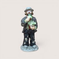 Vintage Flambro Emmett Kelly Jr ceramic figurine of Weary Willie eating lettuce.