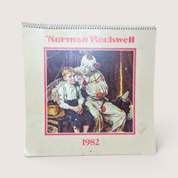 1982 Norman Rockwell calendar cover featuring a clown tending to a young boy.