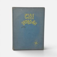 Vintage 1946 first edition hardcover book Fun with Puzzles by Joseph Leeming on a plain background.