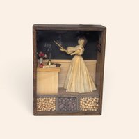 Vintage wooden shadow box diorama featuring a corn husk doll teacher, a blackboard, and compartments filled with dried beans.