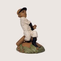Vintage 1980s Tom Clark Cairn Studios "Joltin Joe" baseball player figurine seated with a bat on a leaf and acorn base.