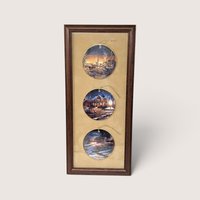 Vintage 1990s Terry Redlin set of three porcelain holiday ornaments featuring winter landscapes, professionally mounted in a wooden frame.